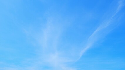 A clear blue sky with a few wispy clouds. The sky is bright and serene, indicating a sunny day with...