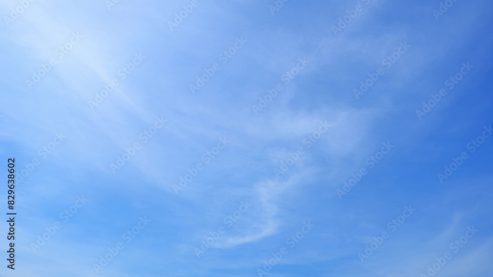 Wall mural a serene blue sky with a few soft, wispy clouds dispersed throughout. the gentle clouds add a sense 
