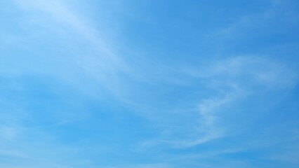 A clear blue sky with a few wispy clouds spread across it. The clouds add a touch of softness to...