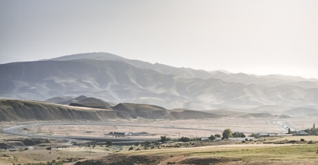 Panorama of mountains, hills and fields in the mountains of Tajikistan, spacious landscape for background on a sunny summer day