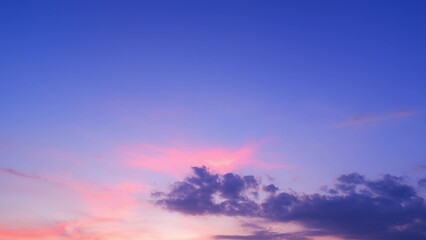 A tranquil sunset with the sky transitioning from deep blue to soft pink and purple hues. A few...