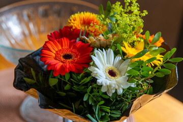 bouquet of flowers in a black plastic bag with a clear bowl behind it