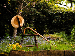 Rickety old chair and walking stick in English flower garden 