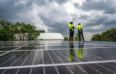 Two diversity solar engineer men working together with solar panels on rooftop