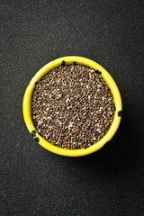Close up of chia seeds in a ceramic bowl. Superfood On a dark concrete background.