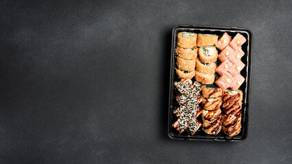 Sushi set. Sushi rolls with fish, caviar and avocado in a plastic disposable dish. Food delivery.