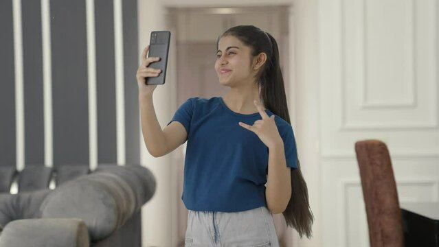 Happy Indian teenage girl clicking selfies