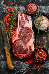 Raw steak. Beef steak with seasonings on a wooden board, close-up.