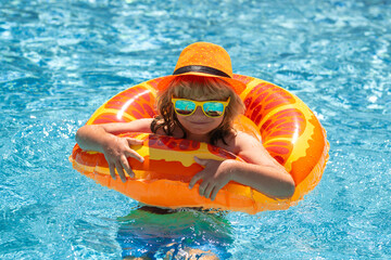 Child splashing in swimming pool. Active healthy lifestyle, swim water sport activity on summer vacation with child. Child water toys.