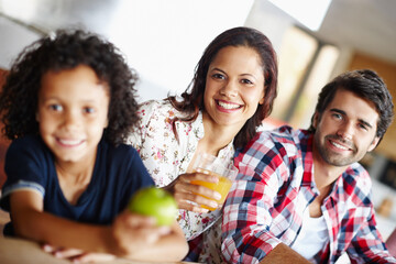 Happy, family and healthy brunch at table together for wellness, corn and juice for nutrition. Diversity, Man and woman with child in home for development with fresh diet or salad, eating in kitchen