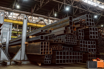 Naklejka premium Warehousing workshop of rolled metal constructions in industrial metalwork production hall. Steel closed profiles metal structures in stack.