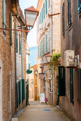 Vertical view of narrow medieval cobbled street in old Mediterranean town, on sunny afternoon