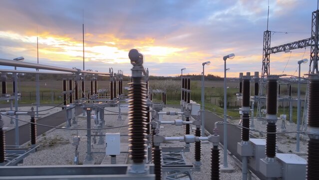 Close up of High voltage sub station for electric power distribution Long-range energy transmission during epic sunset