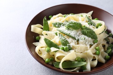 Delicious pasta with green peas and cheese on grey table, closeup
