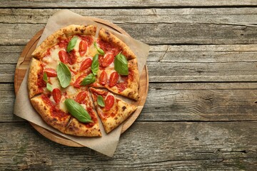 Delicious Margherita pizza on wooden table, top view. Space for text