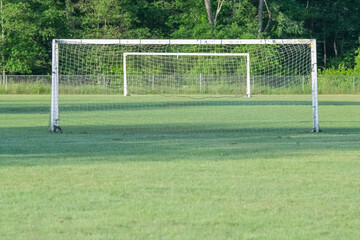 Soccer field amateur field, goal post, selective focus, green grass, summer fun sports