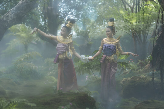 Beautiful girl in a Kinnari dress in green natural with the moss and mist. Kinnari is an animal in the Himmapan forest in Thai literature.