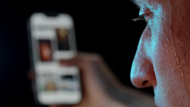 A Man Scrolling So Fast Through Social Media That Sweat Drops Down His Face, Which He Wipes Away with His Hand, Internet Addiction.