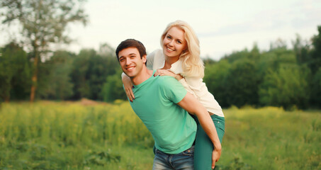 Portrait of beautiful happy smiling young couple in love together hugging in summer park