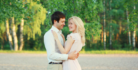 Fototapeta premium Portrait of beautiful happy smiling young couple in love together hugging in summer park