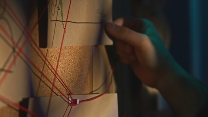 Close-up of board with notes and threads. Stock footage. Man is investigating and fixing evidence...