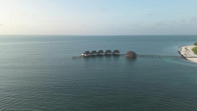 Aerial view towards luxurious thatched roof Kae Funk chalets Indian ocean beach resort in Zanzibar Chwaka bay