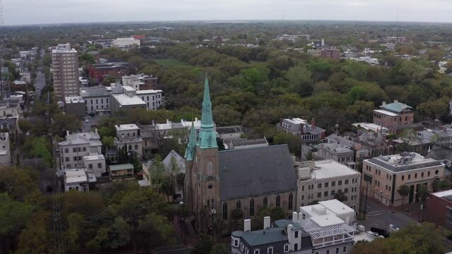 Aerial wide descending shot of the Wesley Monumental United Methodist Church in downtown Savannah, Georgia. 4K
