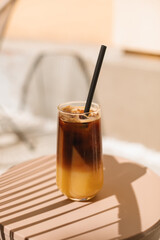 Refreshing bumble coffee in a glass on table on summer terrace.