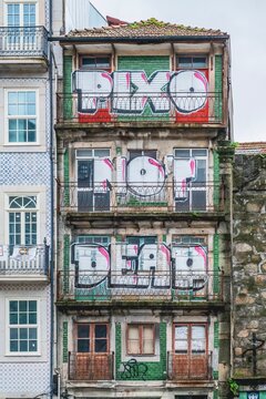Facade of an old building in the city of Porto in Portugal with the text &ldquo;Pixo don't Dead&rdquo; written on its balconies.