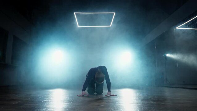 Talented woman dancing in dark smoky studio. Sensual dance on heels. High hells. Female dancing in studio with smoke and spotlight. Performance. 4K, UHD