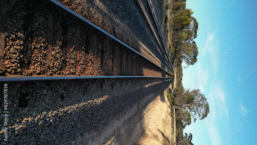 Poster drone flying at low altitude over train rails in rural landscape. aerial forward and slow-motion. ve