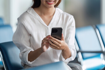 Woman use smartphone while waiting for her flight in airport lounge. travel concept