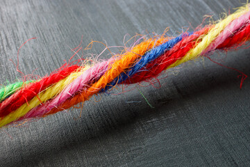 Close-up of a rope made of colored threads as a symbol of unity and inclusion.