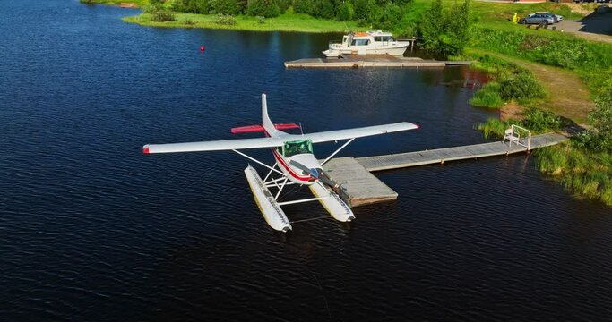 AERIAL: Seaplane docked at a pier on lake Inari, sunny, summer day in Finland