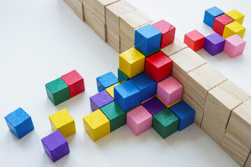 Colored cubes overcome an obstacle in the form of a wall. Creativity or diversity and inclusion...