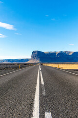 A long road with a mountain in the background