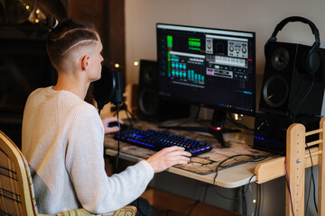 Young happy dj man wearing headphones and working at home. Making music or melody in special app