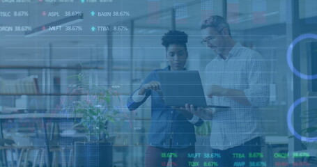 Image of graphs and trading boards, diverse coworkers discussing reports on laptop in office