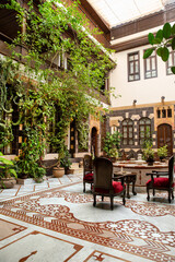 Interior of luxury hotel in oriental style with living plants and fountain in the lobby