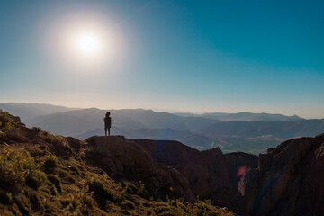 summer camp. boy with a backpack. a boy with a backpack walks along a path against the background of mountains. travel and hiking. traveling with children to the mountains.