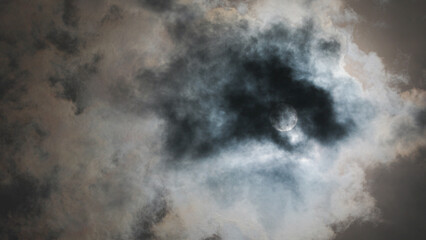 Solar eclipse with moon shining through dark clouds in Waco, Texas