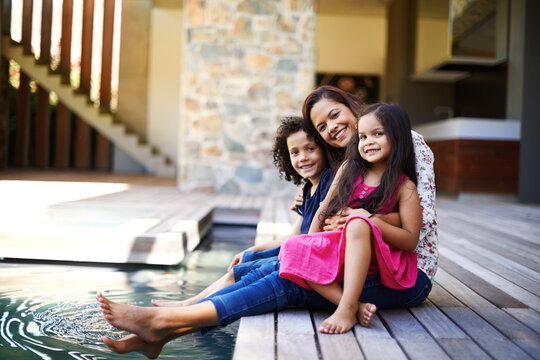 Hug, portrait and family at swimming pool of home together for bonding, relax or summer time off. Happy, love or smile with mother, son and daughter embracing outdoor in garden for relationship
