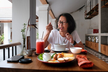 Woman eating alone in a small opened kitchen restaurant