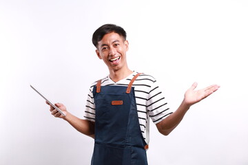 Young happy smiling asian man barista bartender barman employee wear blue apron work in coffee shop...