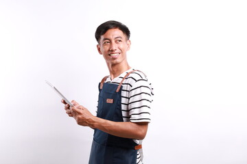 Smiling young Asian man barista barman employee wearing blue apron work in coffee shop holding...