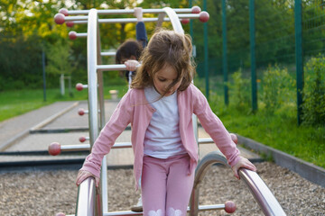Beautiful little girl preschooler on a summer playground
