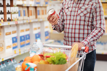 Man reading a food label at the supermarket