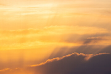 Vibrant orange sunset sky with fluffy clouds