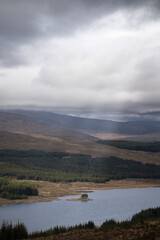 Scenic view of a lake with mountains in the background from a hilltop.