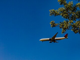 Aerial shot of a commercial airliner coming in for a landing on a sunny day with clear blue skies.